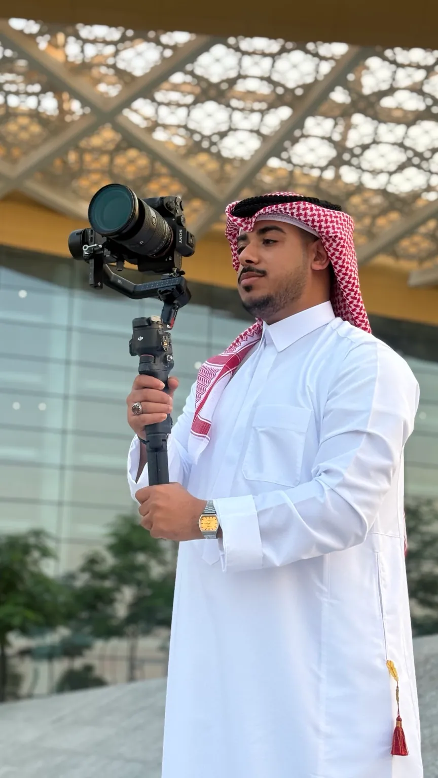 علي، مؤسس نكست شوت، يحمل كاميرا على مثبّت أثناء تصوير ميداني